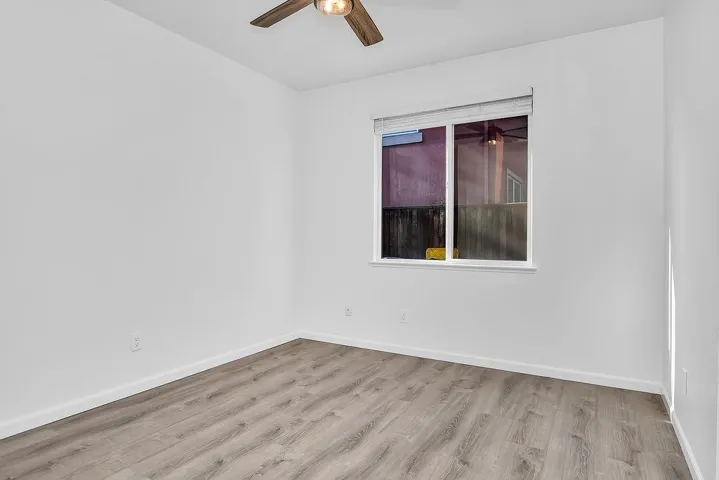 Spare room featuring light wood-style flooring and baseboards