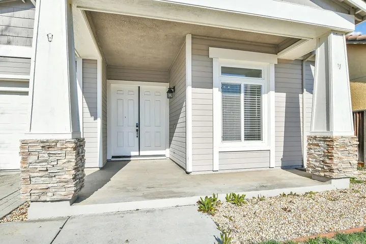 Entrance to property with stone siding and covered porch