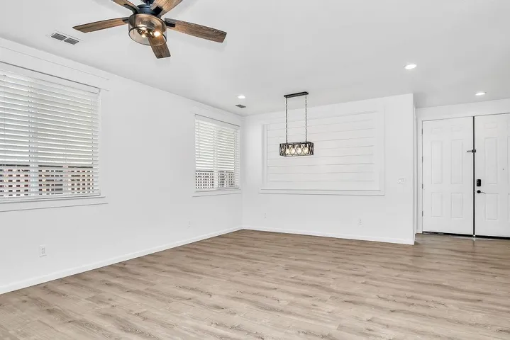 Unfurnished dining area featuring light wood-style floors, a ceiling fan, and recessed lighting