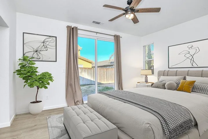 Bedroom with access to exterior, wood finished floors, and a ceiling fan