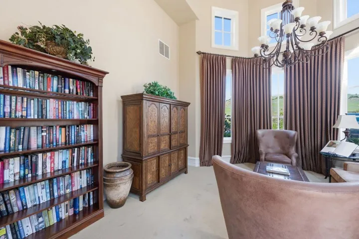 Sitting room featuring light colored carpet and a chandelier
