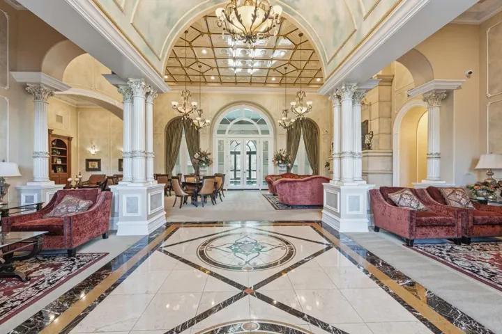 Building lobby featuring ornamental molding, a towering ceiling, and coffered ceiling