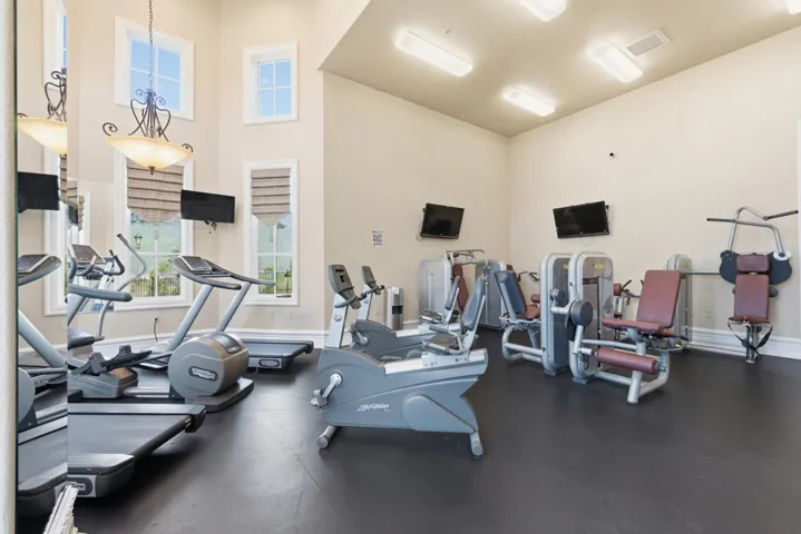 Exercise room featuring a towering ceiling