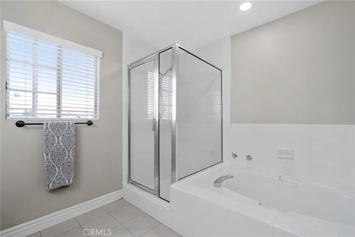 Full bath with step-in shower and separate soaking tub upstairs.
