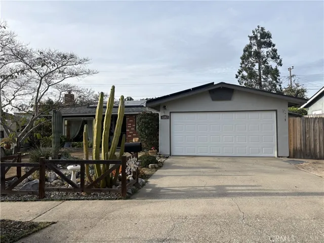 Front view with parking in garage, driveway and gate to the side yard.