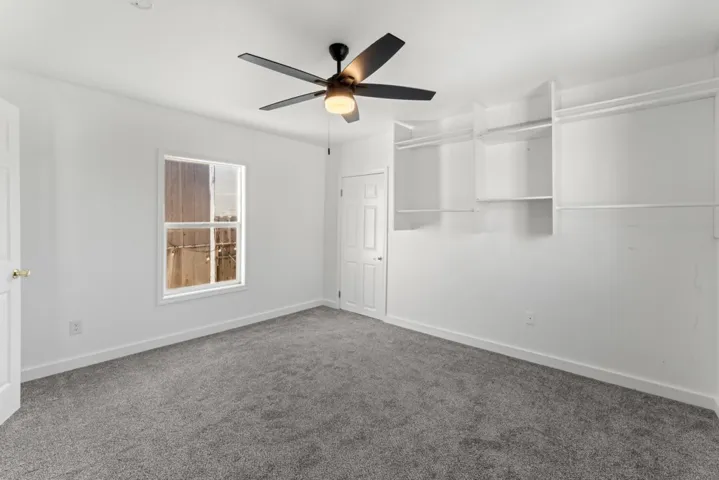 Unfurnished bedroom with carpet flooring and a ceiling fan