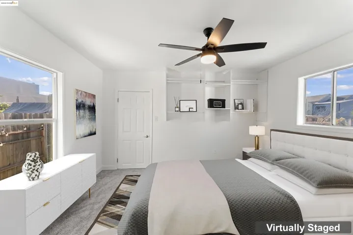 Carpeted bedroom featuring multiple windows and a ceiling fan