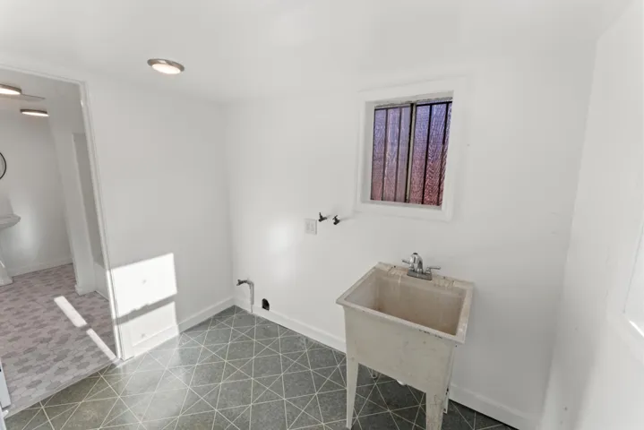 Washroom featuring baseboards and a sink