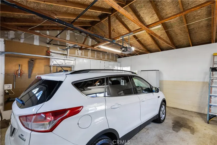 Garage has shelving, storage bins, and working refrigerator- Car not included - tools, ladders, etc  stay with house