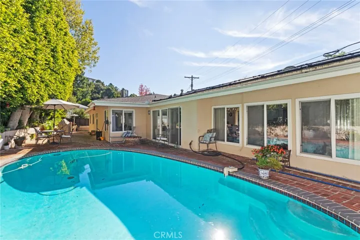 Pool/Patio Area - features robotic pool vacuum, low-maintenance coping/patio, built-in gas fire pit, and manicured mature ficus trees that provide privacy screening.