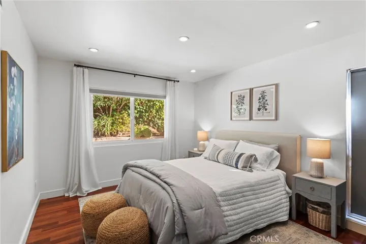 Bedroom 2/Guest - features hardwood flooring, recessed LED lighting, full-size closet, and views of the private pool area.