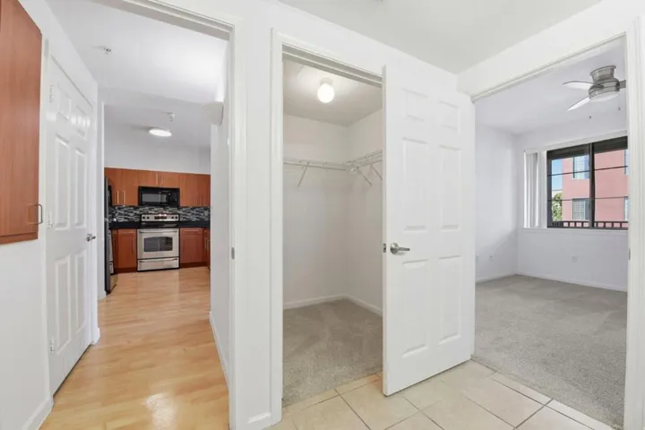 View from bathroom, of bedroom, walk-in closet, and hallway to kitchen.