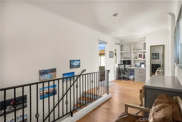 Upstairs landing, with cabinets, desk and balcony.