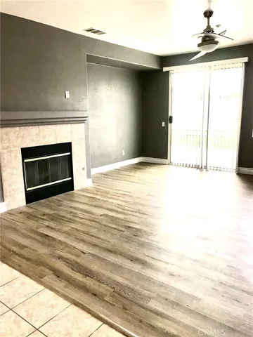 Spacious Family Room with Custom-Vinyl Maple-Wood Designer Floor,Fireplace and Ceiling Fan, sliding door and Vertical Blinds. Niche for Entertainment T.V. set.