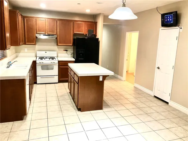Spacious Kitchen, white tiles and Wood Cabinets