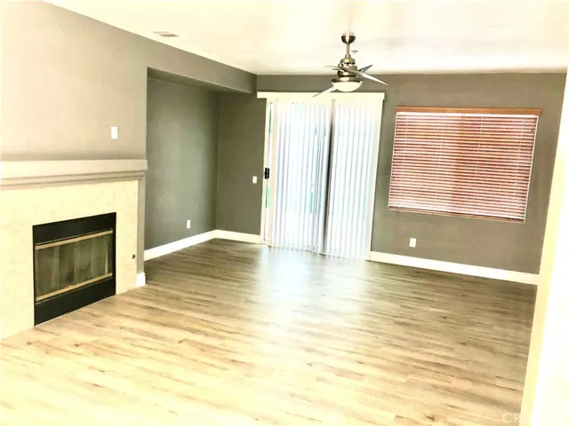Spacious Family Room with Custom-Vinyl Maple-Wood Designer Floor,Fireplace and Ceiling Fan, sliding door and Vertical Blinds. Niche for Entertainment T.V. set.