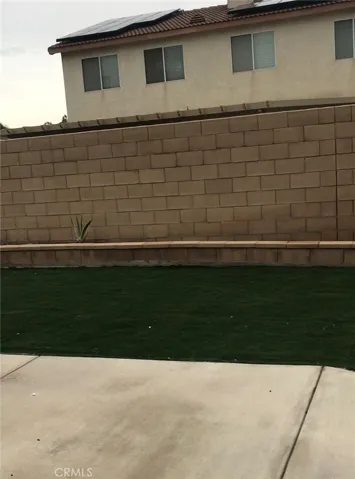 Good-size Backyard with concrete slab, and evergreen turf.