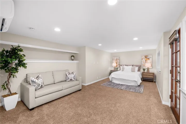 Bedroom #5 with sitting area and door to side yard deck.