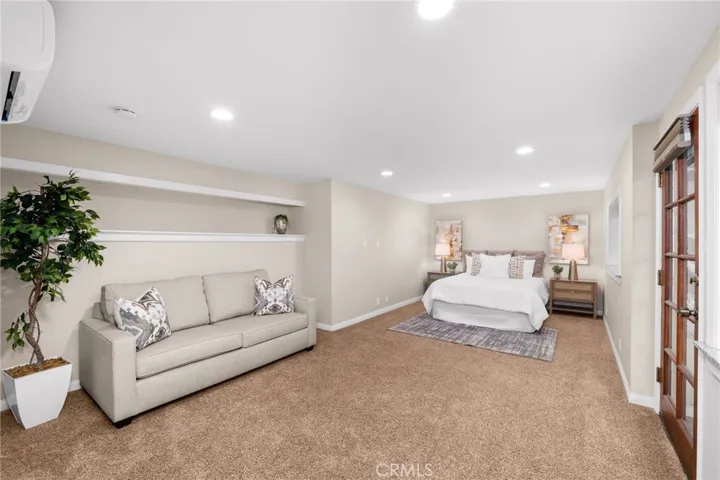 Bedroom #5 with sitting area and door to side yard deck.