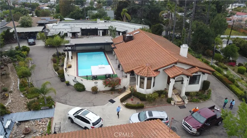 view of detached garage and subject property w/ pool, white home in background is neighbor