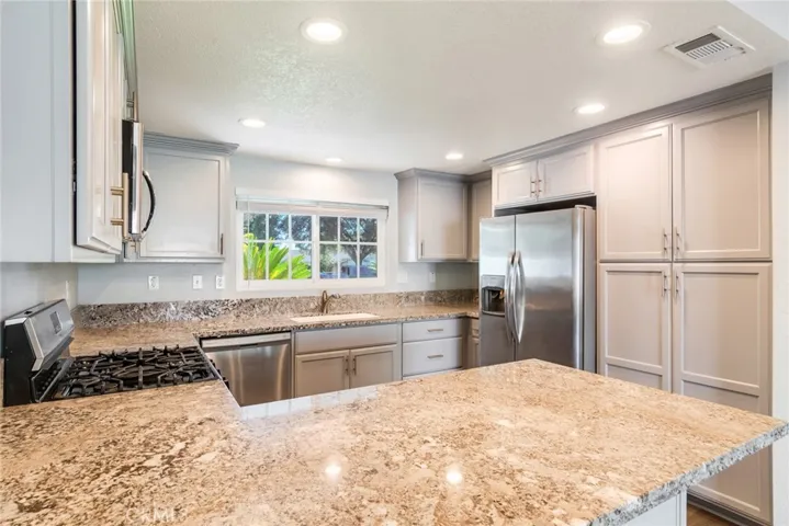Stunning kitchen with gray cabinetry and updated stone countertops.