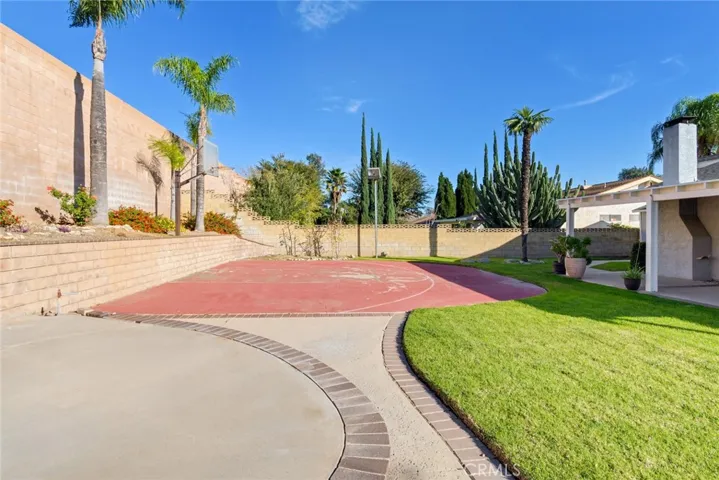The backyard is an entertainer's dream featuring a covered patio with sports court and plenty of space for BBQs and parties.