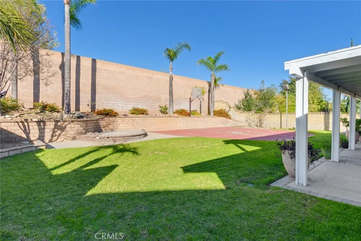 The backyard is an entertainer's dream featuring a covered patio with sports court and plenty of space for BBQs and parties.