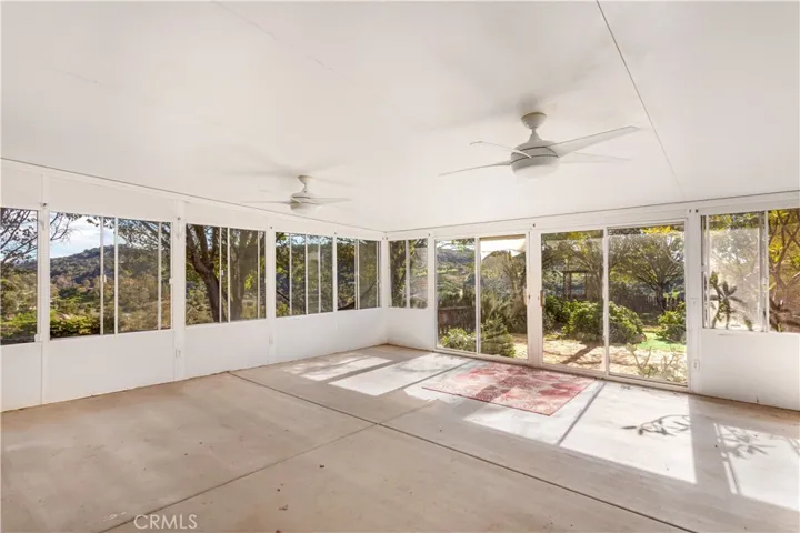 The enclosed sunroom with forever views and garden areas outside.