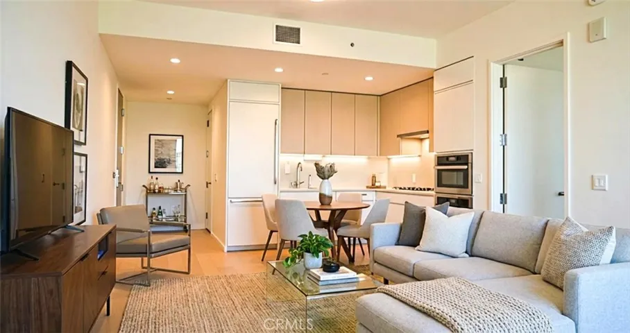 Virtually staged living room/kitchen open concept area.