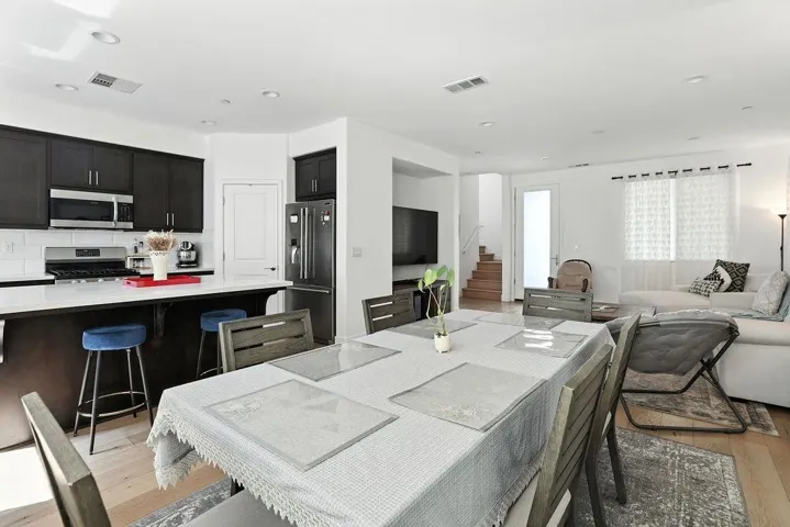 Dining space with stairway, light wood-style flooring, and recessed lighting