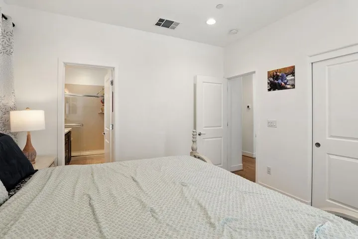 Bedroom with recessed lighting, connected bathroom, and wood finished floors
