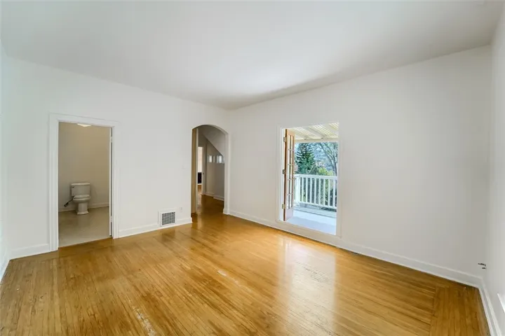 Reverse view primary bedroom, bathroom, hallway, exterior open balcony porch to upper brick patio