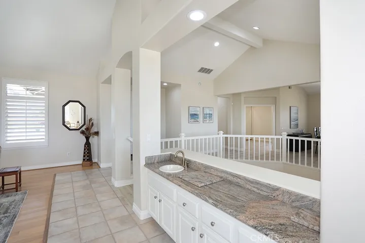 Wet bar in living room facing entry and door way to bedroom