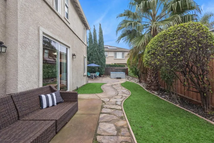 Fenced backyard with a hot tub and a patio area