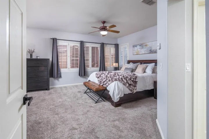 Carpeted bedroom with baseboards and ceiling fan