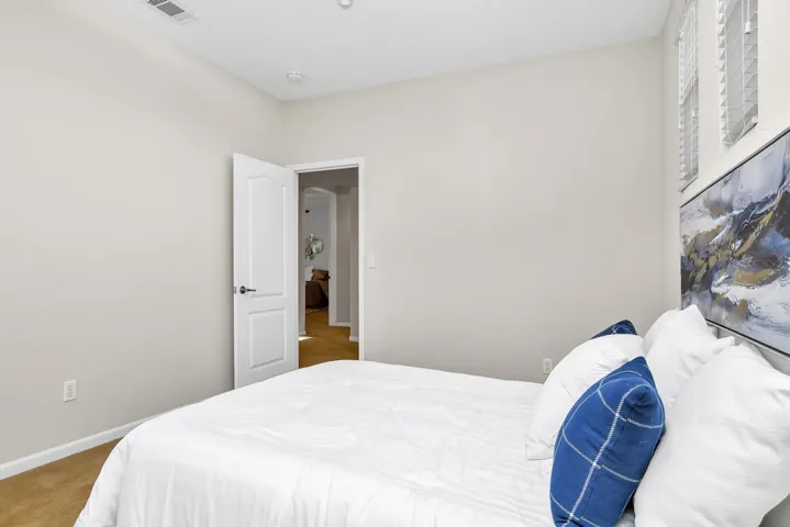 Bedroom with light colored carpet and baseboards