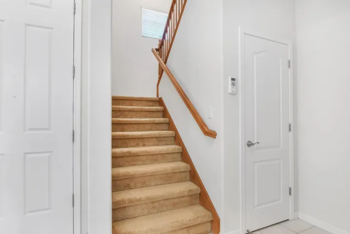 Staircase with tile patterned flooring and baseboards