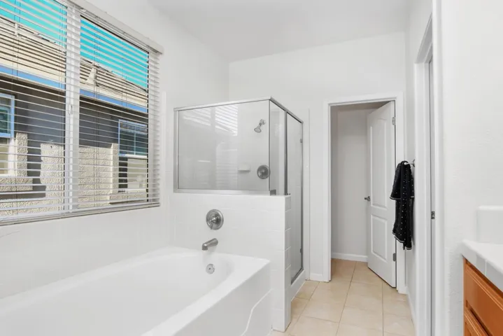Full bath featuring plenty of natural light, a bath, vanity, and a stall shower