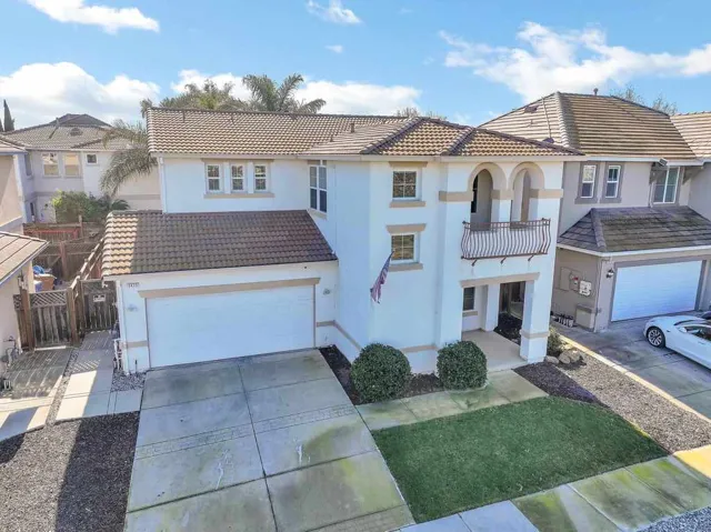 Mediterranean / spanish house with stucco siding, a tiled roof, concrete driveway, and a garage