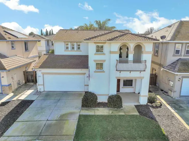 Mediterranean / spanish home with stucco siding, driveway, a balcony, and a tile roof