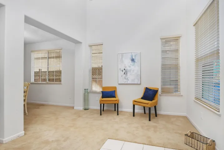 Sitting room featuring light colored carpet and a towering ceiling