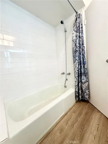 Bathtub in full bathroom besides the shower