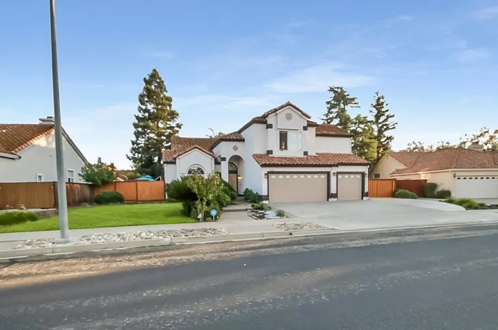 Mediterranean / spanish house featuring concrete driveway, stucco siding, and a tile roof