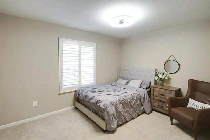 Bedroom featuring light colored carpet and a textured ceiling