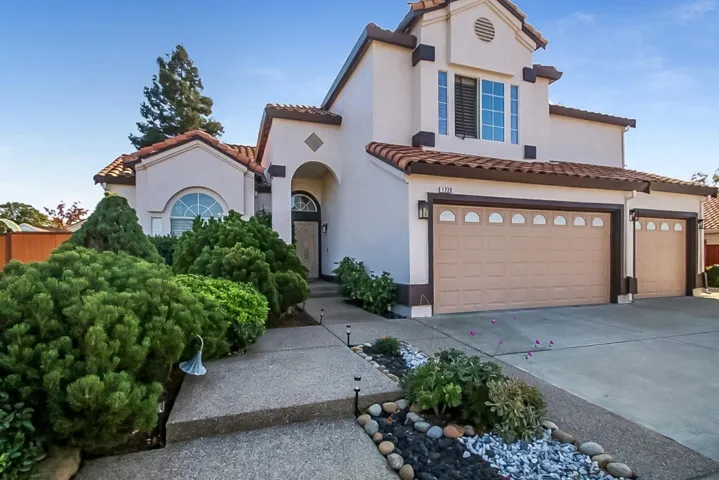 Mediterranean / spanish-style home featuring concrete driveway, stucco siding, and a tiled roof