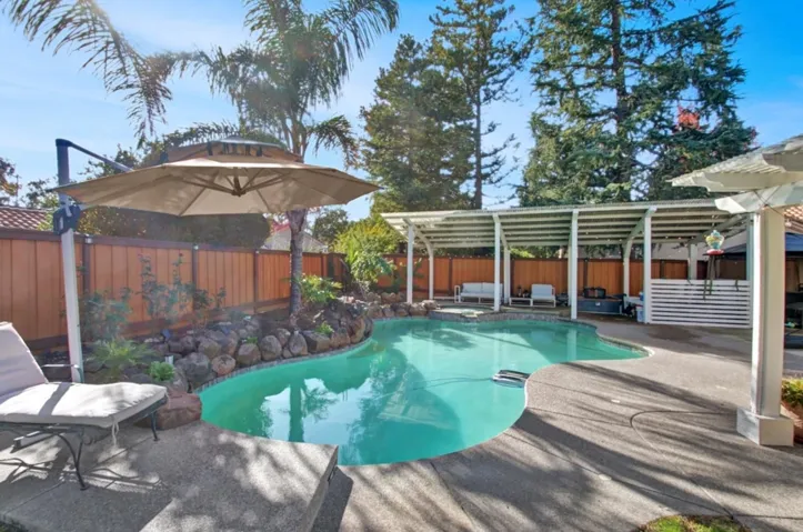 View of pool with a pergola, a fenced backyard, a patio area, and a pool with connected hot tub