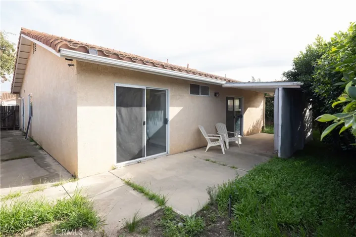A view of the backyard facing the master bedroom double doors and an entrance into the kitchen.