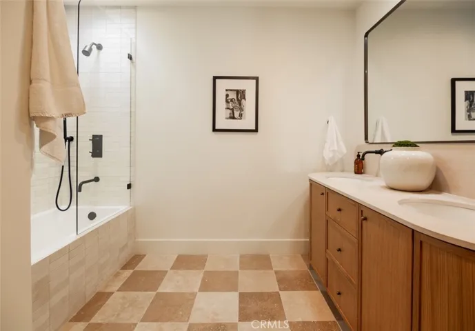 Upstairs hall bath features checked travertine tile floors, separate water closet, tub/shower with single panel glass door.