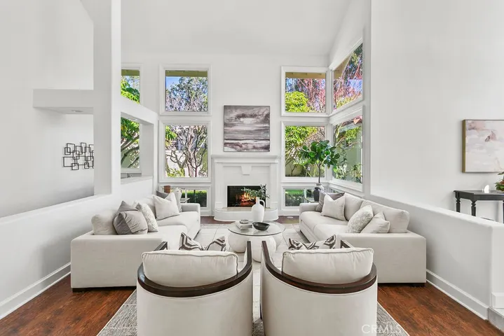 Inviting living room with 2  story ceilings, tall windows, and a zen garden view. Fire in fireplace is virtually created.