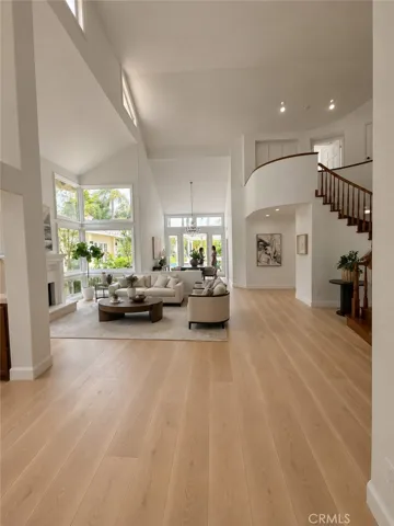 Ai generated view from entry through living room with flooring and elevation change plus new flooring and removal of pony walls.  Do you like this image better?